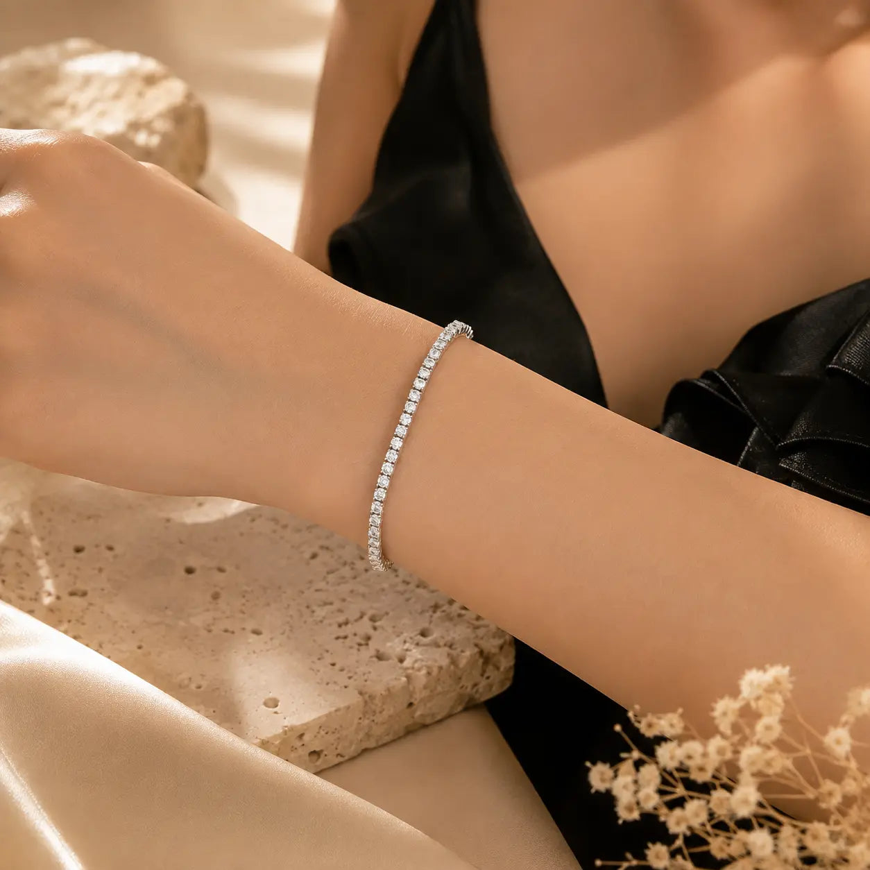 Woman wearing a sparkling Cirelle™ round moissanite tennis bracelet on her wrist in a luxury beige setting.