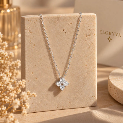 Woman wearing a delicate clover pendant necklace with an elegant neutral outfit