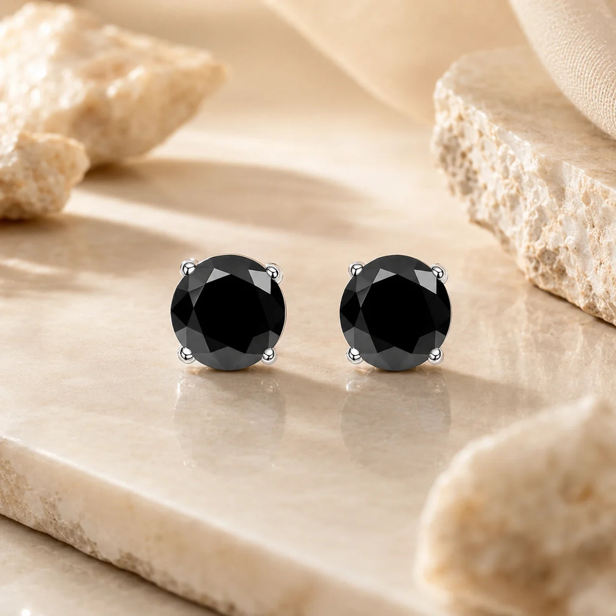 Eloryva black round-cut gemstone stud earrings featuring a polished silver-tone four-prong setting.