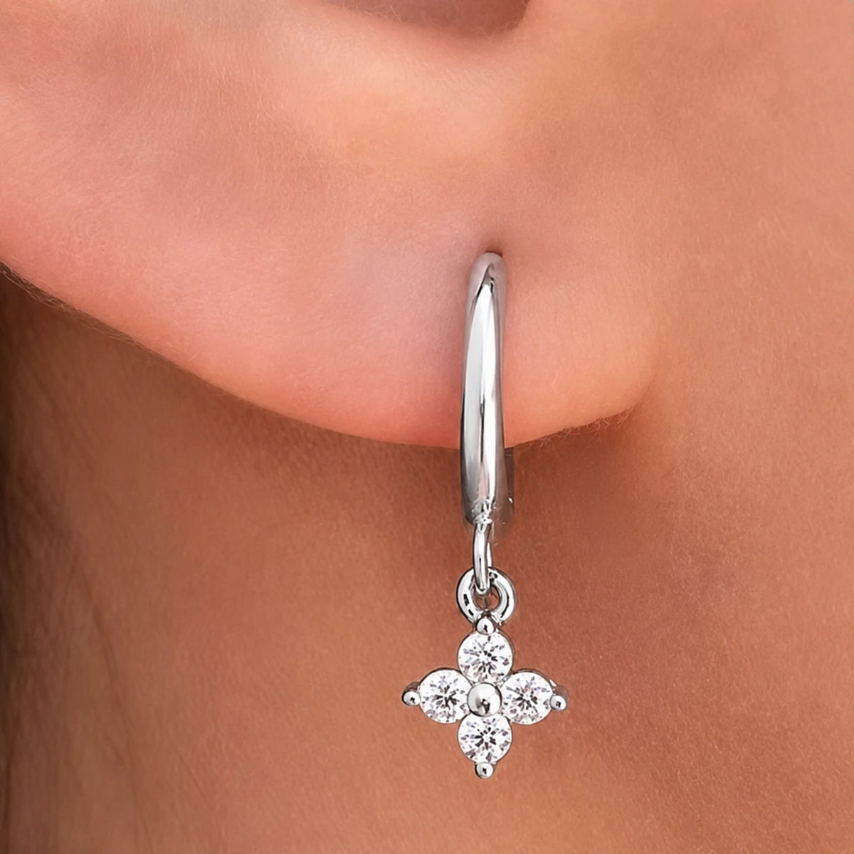 Close-up of a Clovera™ Clover Moissanite Hoop Drop Earring with a delicate clover-shaped moissanite pendant.