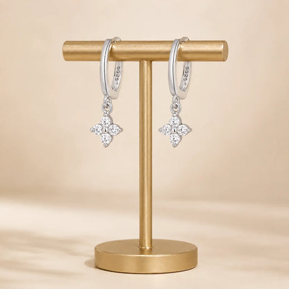 Pair of Clovera™ Clover Moissanite Hoop Drop Earrings displayed on a minimalist gold jewelry stand.