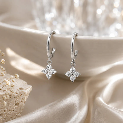 Clovera™ Clover Moissanite Hoop Drop Earrings arranged on soft satin with a warm luxury background.