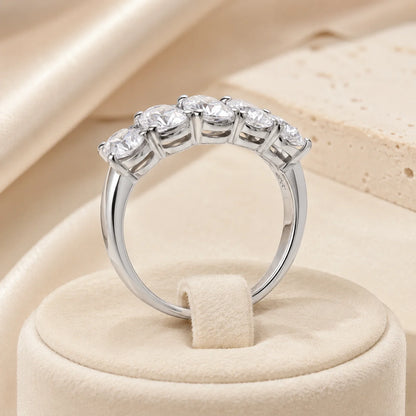 Side view of a silver five-stone moissanite anniversary ring showing the elevated prong settings and polished band.