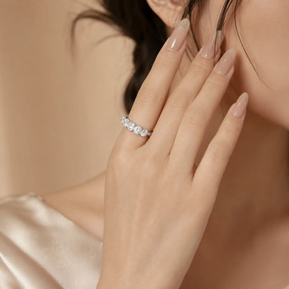 Woman wearing a five-stone moissanite ring with a polished silver band for an elegant everyday look.