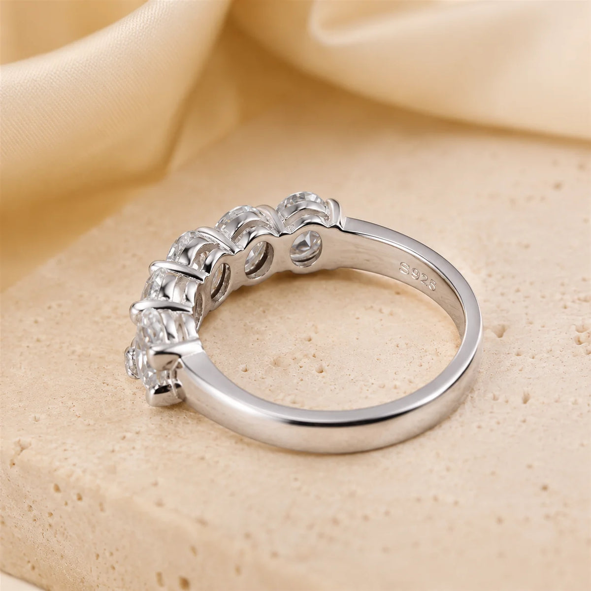 Front view of a five-stone oval-cut moissanite ring featuring brilliant graduated stones in a polished sterling silver setting.