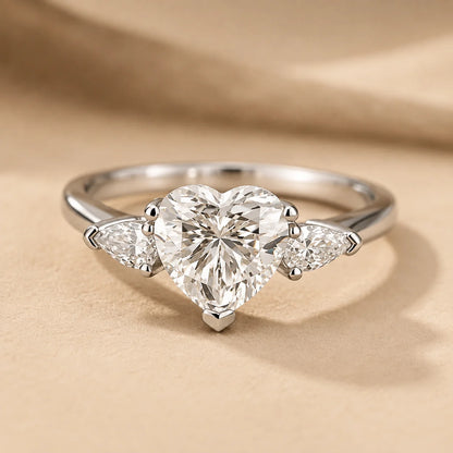 Front view of a heart-cut moissanite engagement ring featuring a brilliant center stone and two delicate side stones.