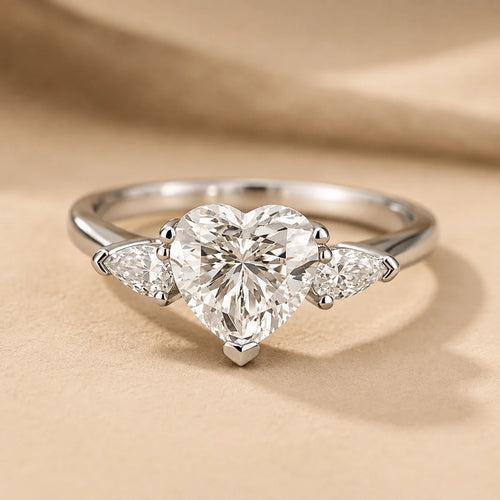 Front view of a heart-cut moissanite engagement ring featuring a brilliant center stone and two delicate side stones.