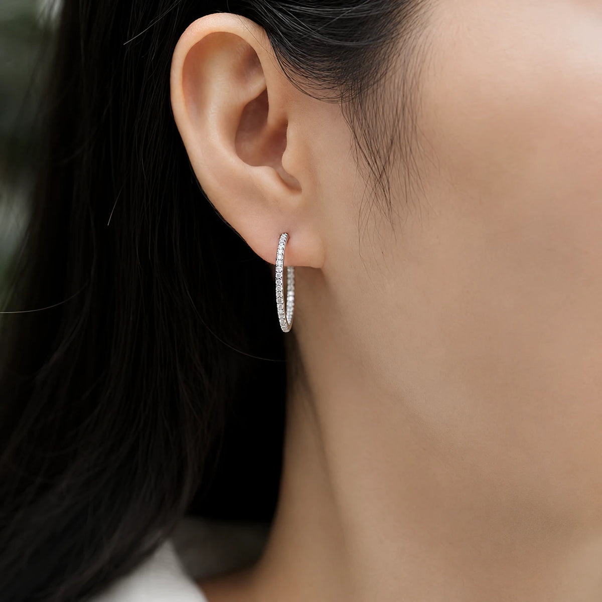 Woman wearing Isadora™ slim moissanite hoop earrings for an elegant and effortless everyday look.