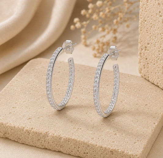 Angled view of Isadora™ slim silver hoop earrings featuring a refined row of sparkling moissanite stones.
