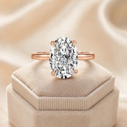Rose gold Marlowe™ Oval Moissanite Engagement Ring displayed on a soft beige velvet jewelry box.