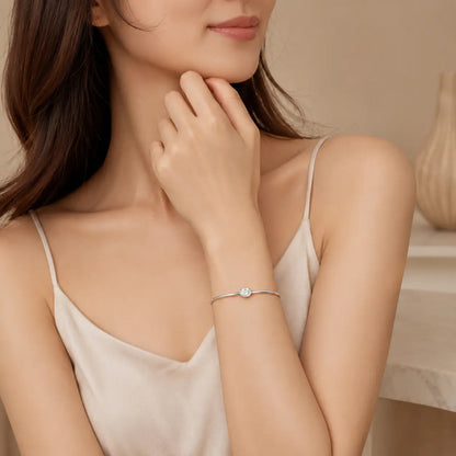 Woman wearing a silver oval-cut moissanite bangle bracelet for an elegant and refined everyday look.