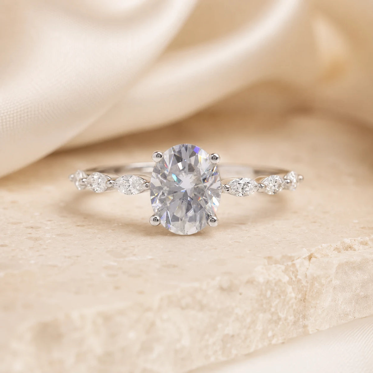 Front view of an oval-cut moissanite engagement ring with sparkling side stones in a polished silver setting.
