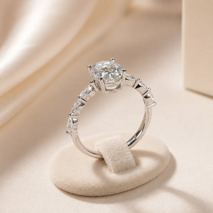 Side profile of an oval moissanite engagement ring showing the raised center setting and stone-accented band.