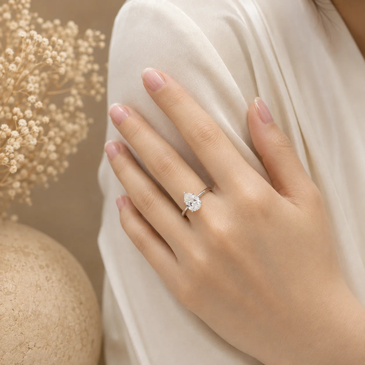 Woman wearing a pear-cut moissanite engagement ring for an elegant and refined look.