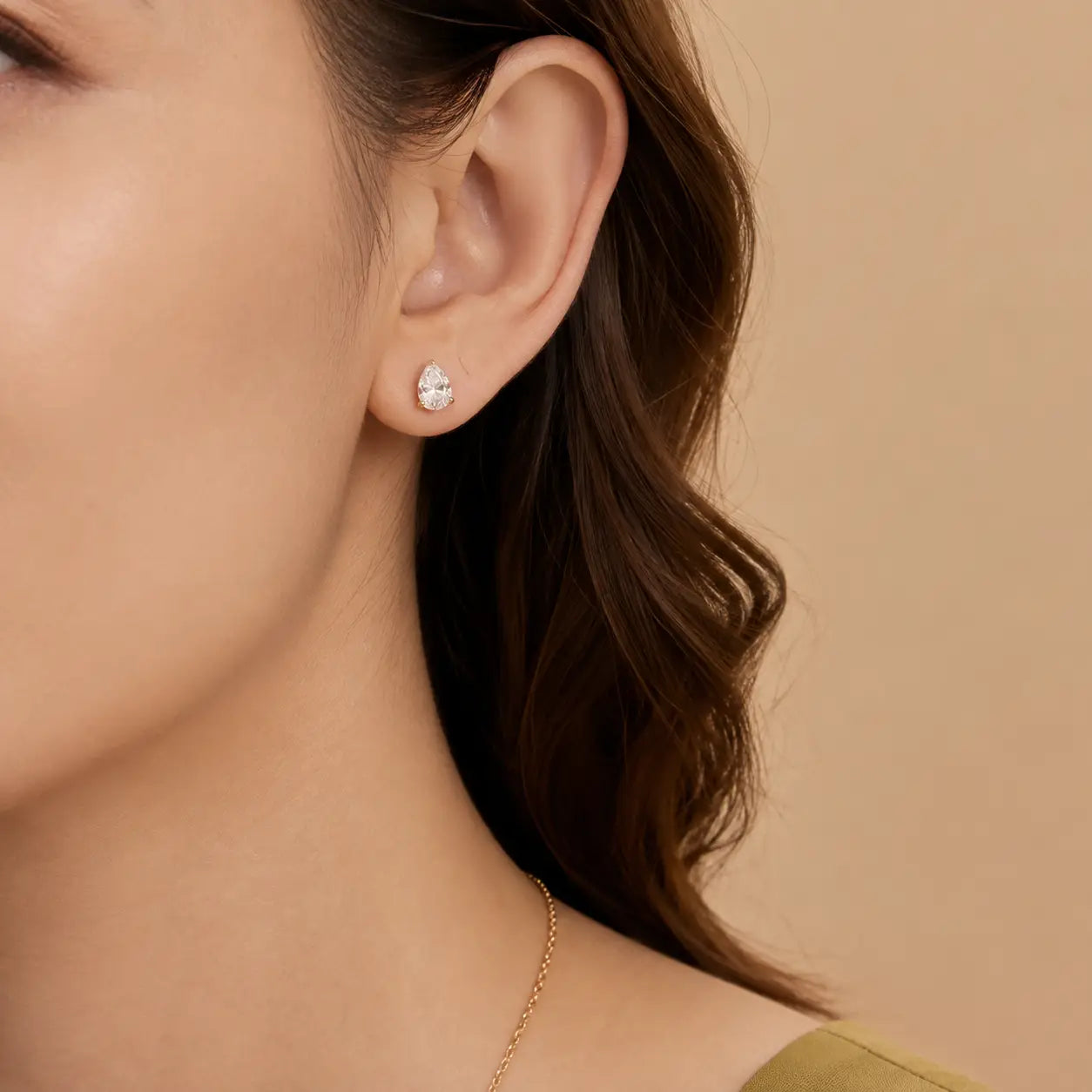 Woman wearing pear-cut moissanite stud earrings for an elegant and refined everyday look.