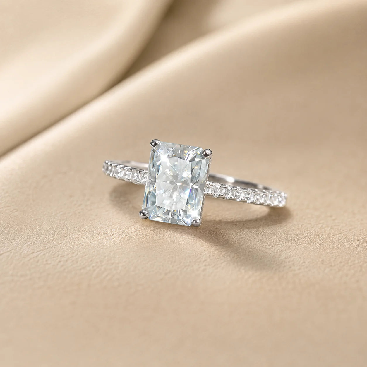 Radiant-cut moissanite engagement ring featuring a brilliant rectangular center stone and delicate pavé-set shoulders.