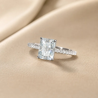 Radiant-cut moissanite engagement ring featuring a brilliant rectangular center stone and delicate pavé-set shoulders.