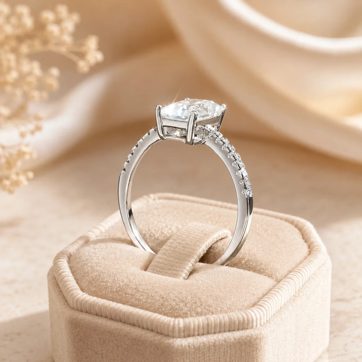 Side profile of a radiant-cut moissanite engagement ring showing the raised four-prong setting and pavé band.