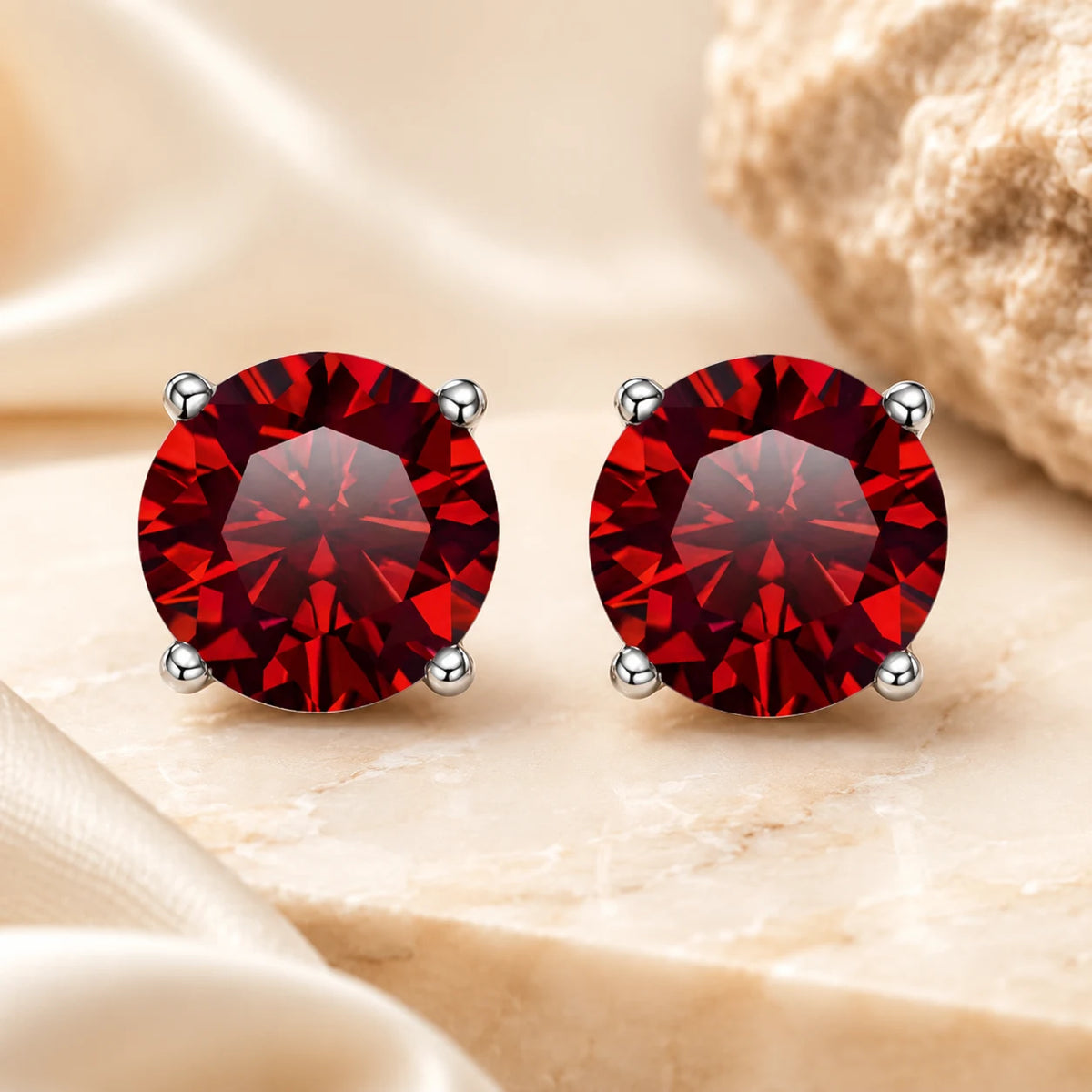 Eloryva red round-cut gemstone stud earrings with a brilliant sparkle and classic four-prong setting.