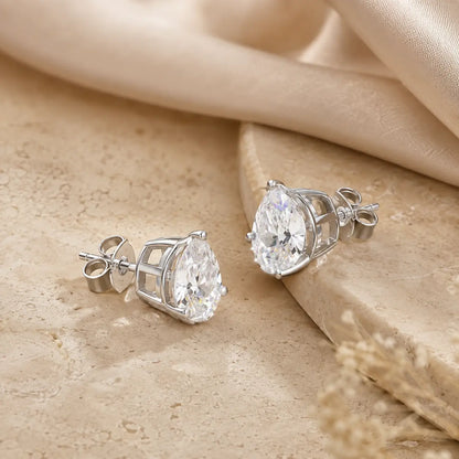 Front and back views of silver pear-cut moissanite stud earrings showing the prong settings and secure posts.