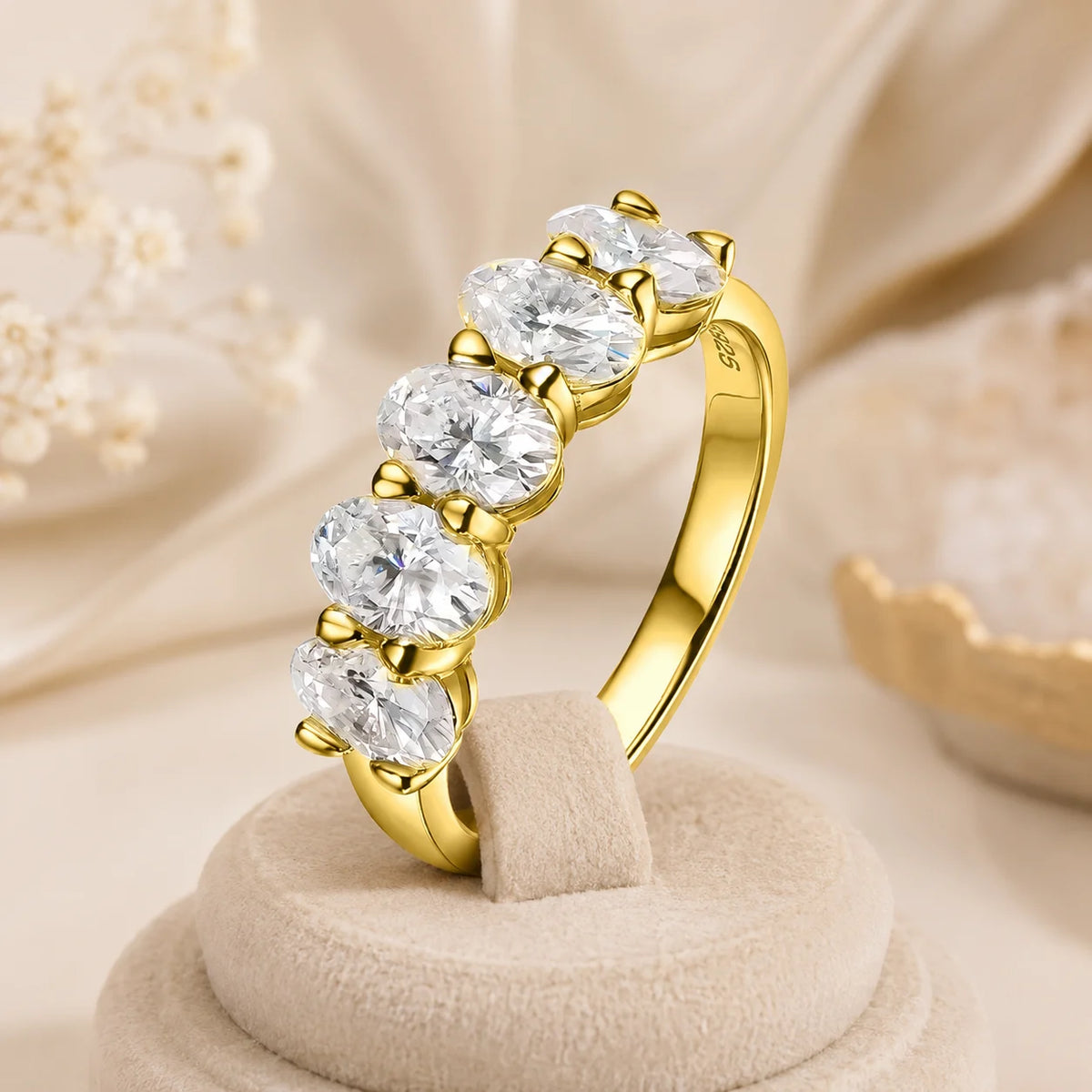 Yellow gold five-stone moissanite anniversary ring featuring brilliant stones in polished prong settings.