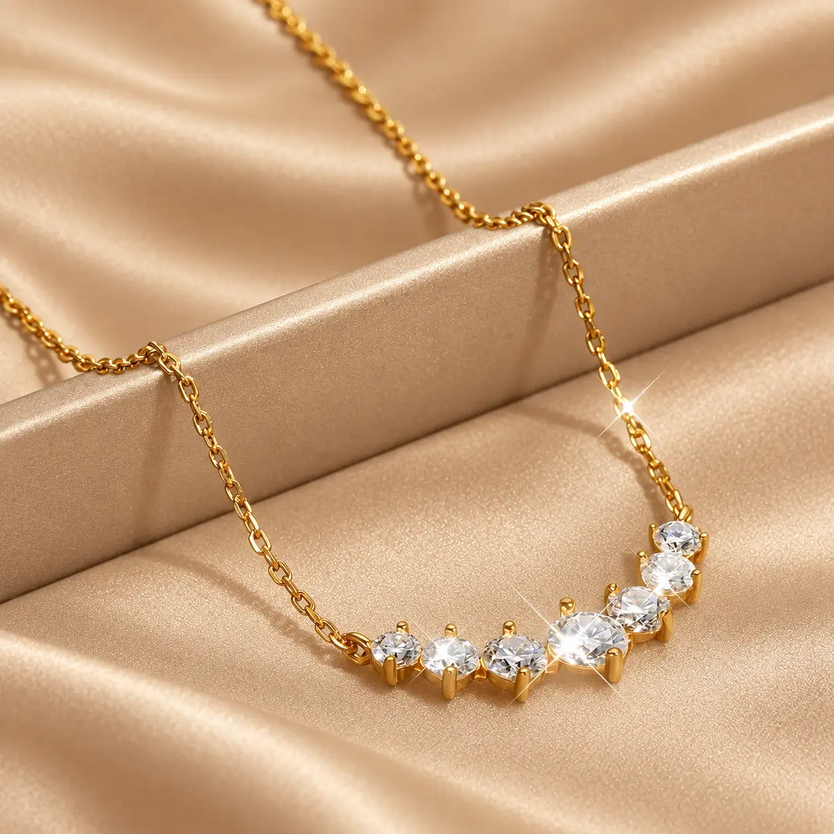 Gold tone graduated moissanite necklace styled on soft champagne satin