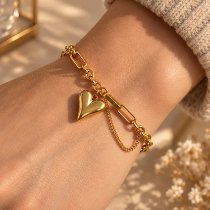 Woman wearing a gold tone heart charm link bracelet on her wrist