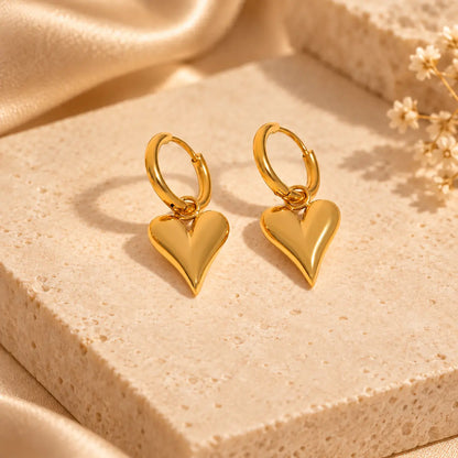 Gold heart hoop earrings with polished dangling heart charms