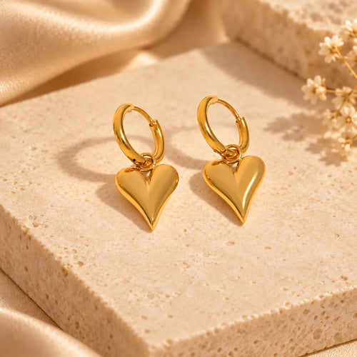 Gold heart hoop earrings with polished dangling heart charms