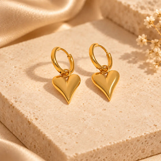 Gold heart hoop earrings with polished dangling heart charms
