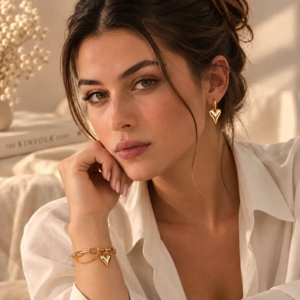 Woman wearing delicate gold heart hoop earrings with a polished finish