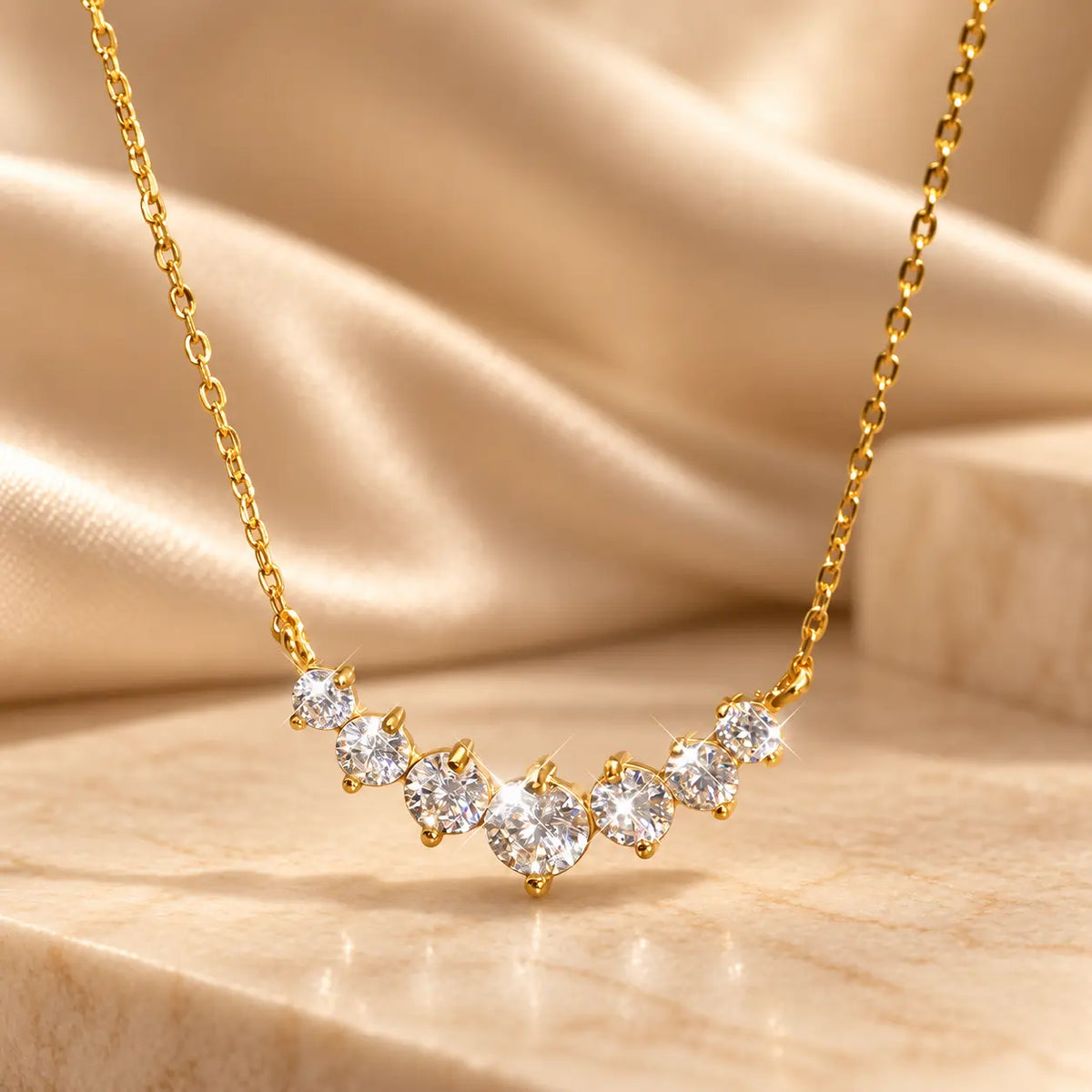 Gold tone moissanite necklace with graduated round stones and a larger center stone
