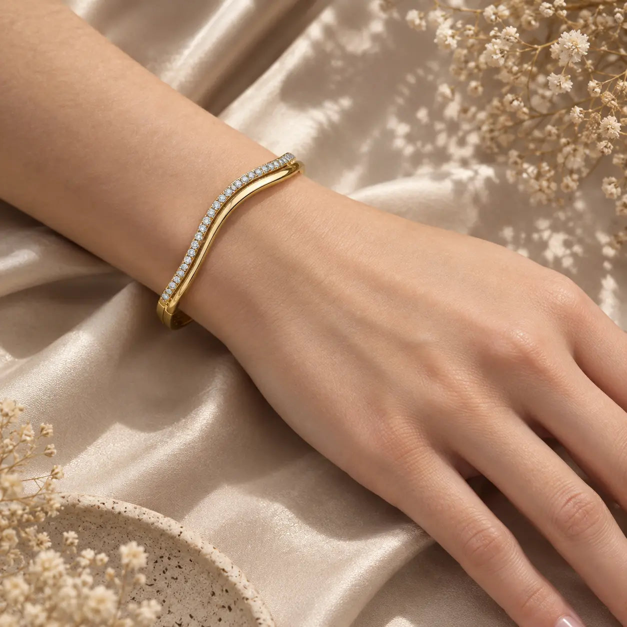 Gold-tone wave moissanite bangle bracelet for women worn on the wrist with a refined everyday jewelry look.