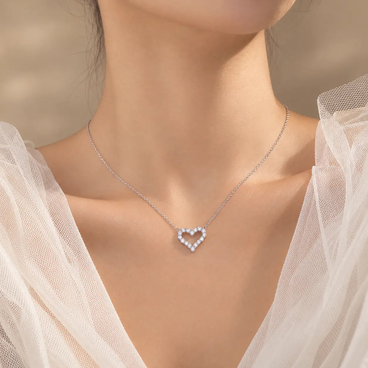 Woman wearing a delicate open heart moissanite pendant necklace