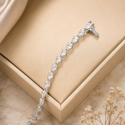 Langley™ pear-cut moissanite tennis bracelet for women displayed elegantly across a champagne jewelry box.