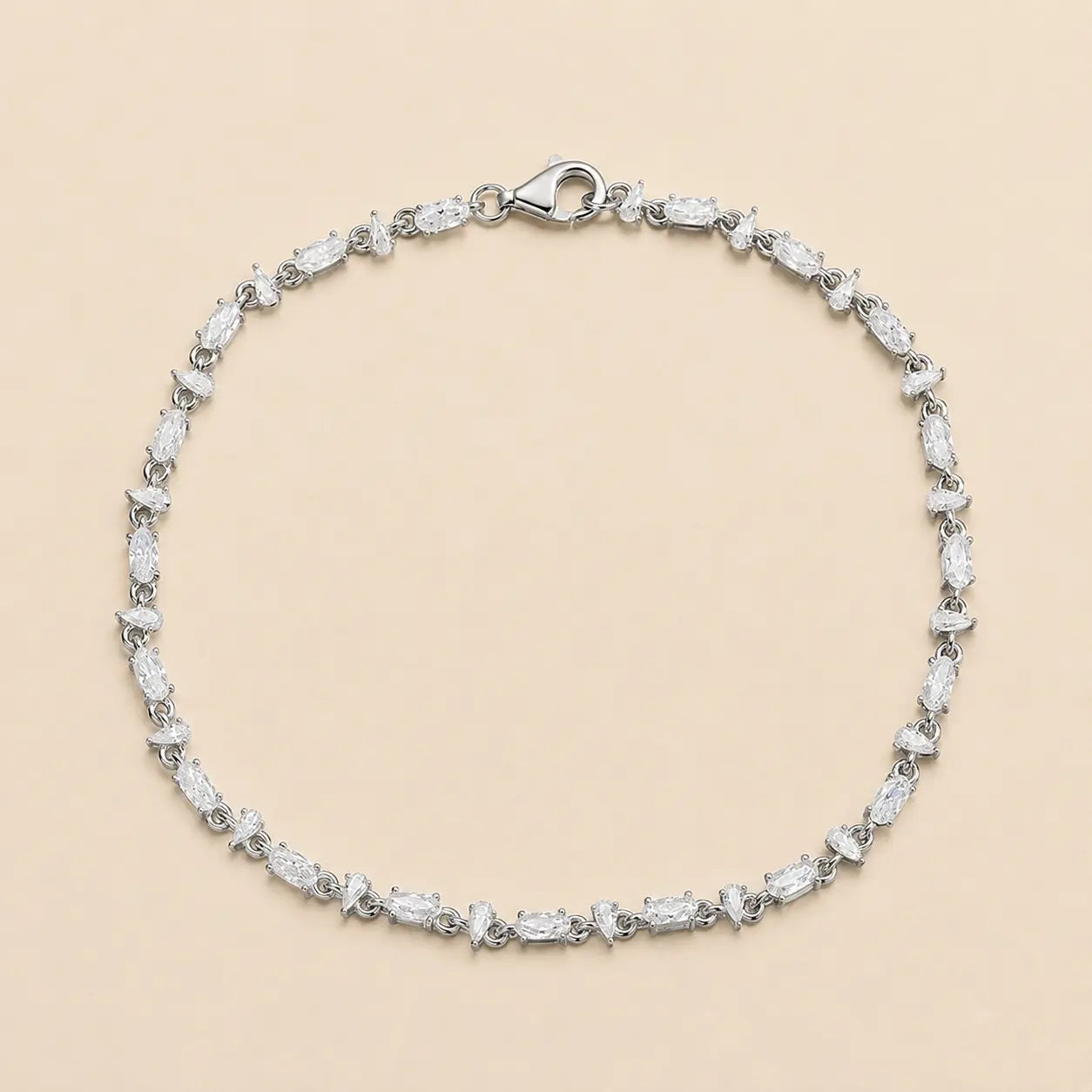 Full view of a mixed-cut moissanite tennis bracelet for women featuring alternating pear and oval-cut stones with a secure lobster clasp.