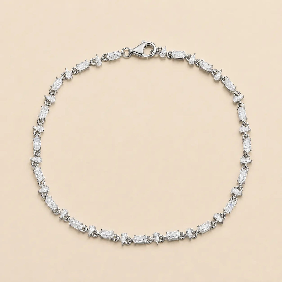 Full view of a mixed-cut moissanite tennis bracelet for women featuring alternating pear and oval-cut stones with a secure lobster clasp.