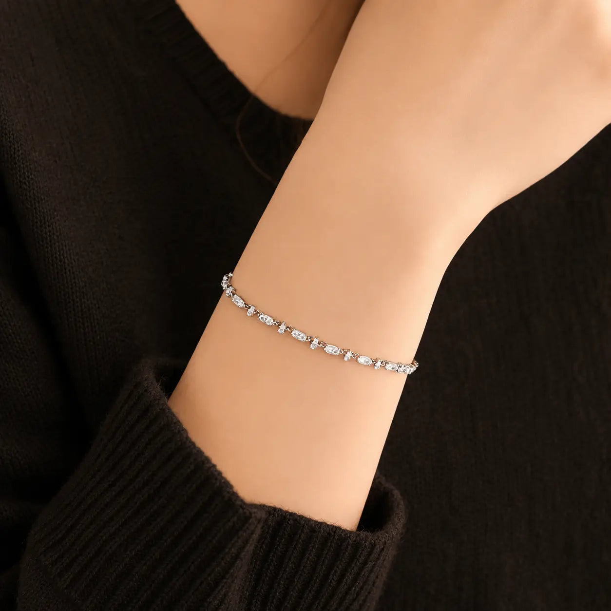 Woman wearing a delicate mixed-cut moissanite tennis bracelet for an elegant everyday jewelry look.