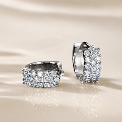 Moissanite hoop earrings displayed on a soft beige background with elegant sparkle and premium silver finish.
