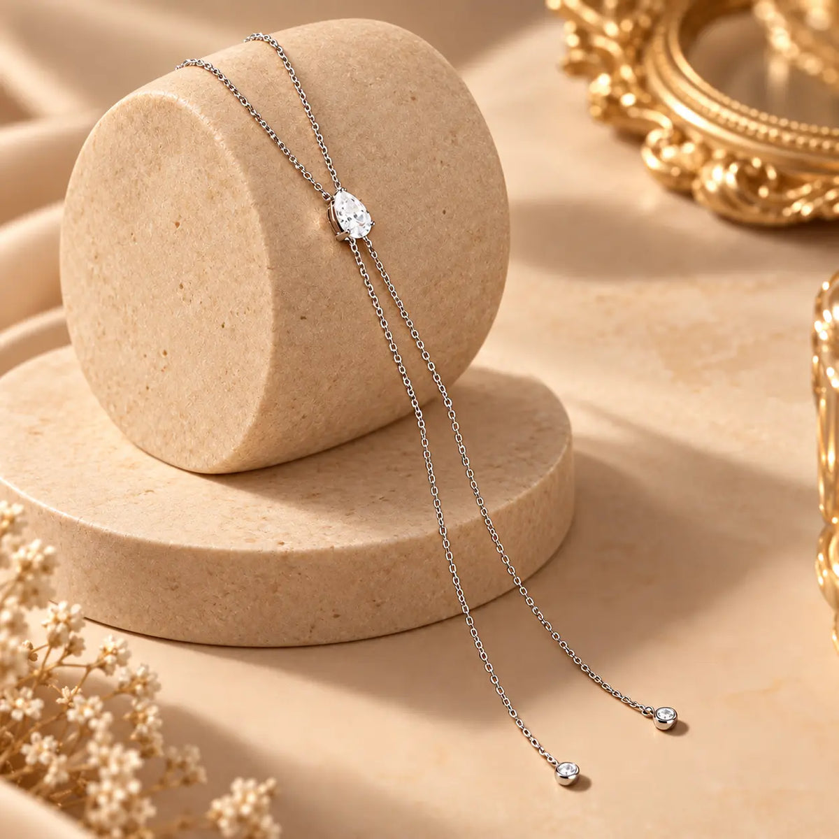 Pear shaped moissanite drop necklace styled on a soft neutral jewelry display