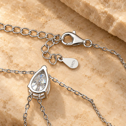 Detail view of a pear cut moissanite lariat necklace showing the pendant setting and clasp
