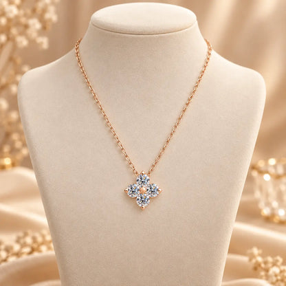 Rose gold tone clover pendant necklace styled on a soft neutral jewelry bust