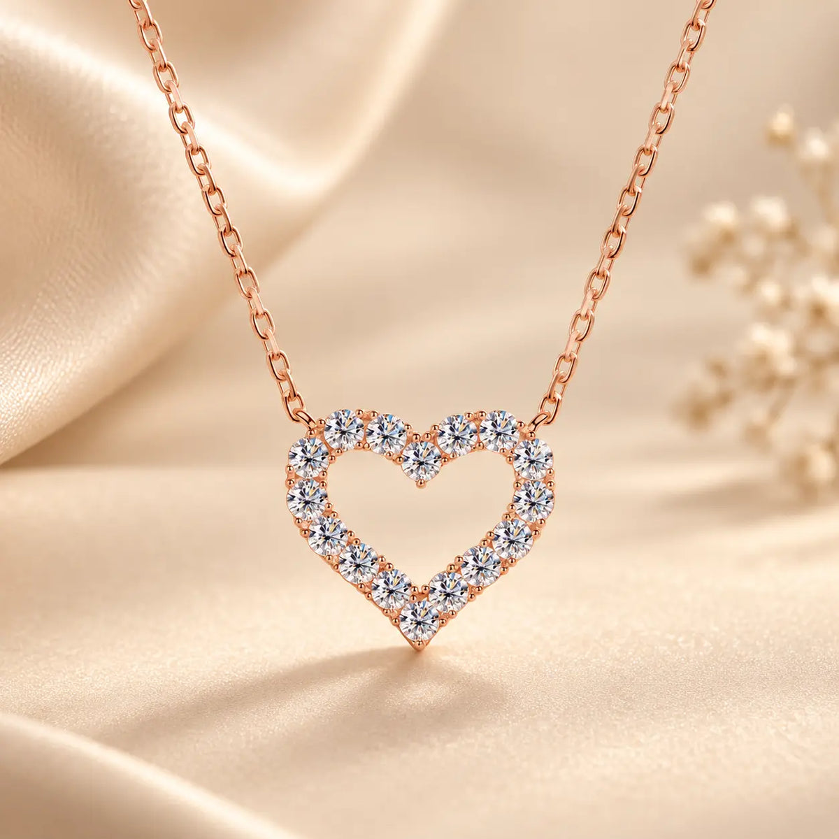 Rose gold tone open heart moissanite pendant necklace styled on soft champagne satin