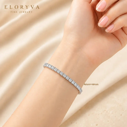 Woman wearing a sparkling 4mm round moissanite tennis bracelet on the wrist in a luxury beige setting.