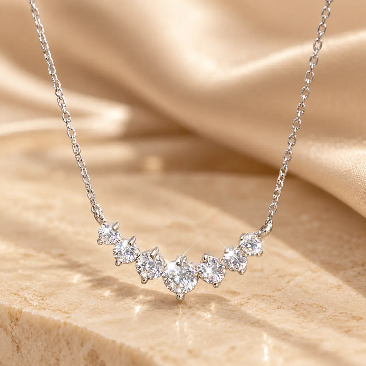 Silver tone graduated moissanite necklace with a sparkling curved row of stones