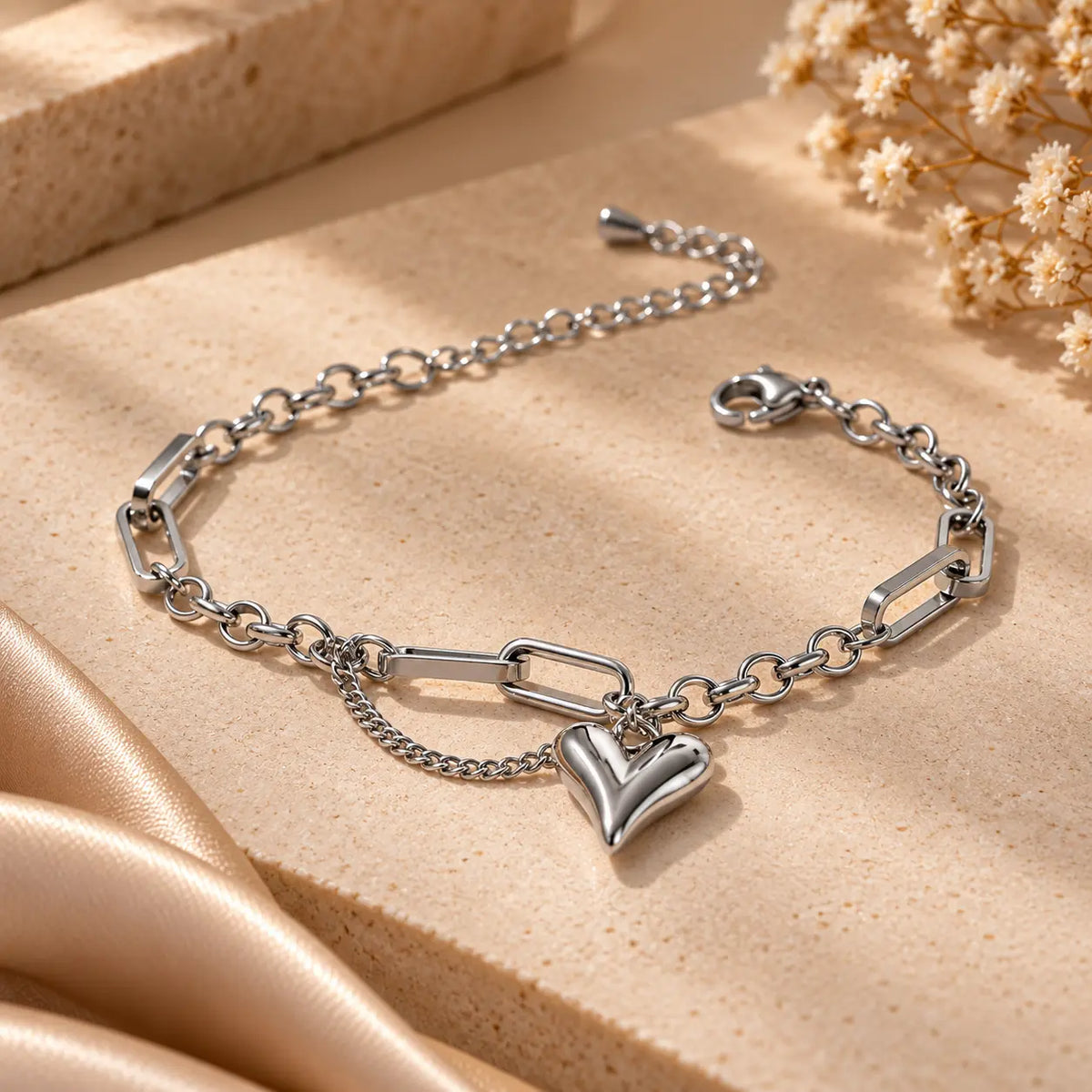 Silver tone heart charm link chain bracelet shown in a close product view