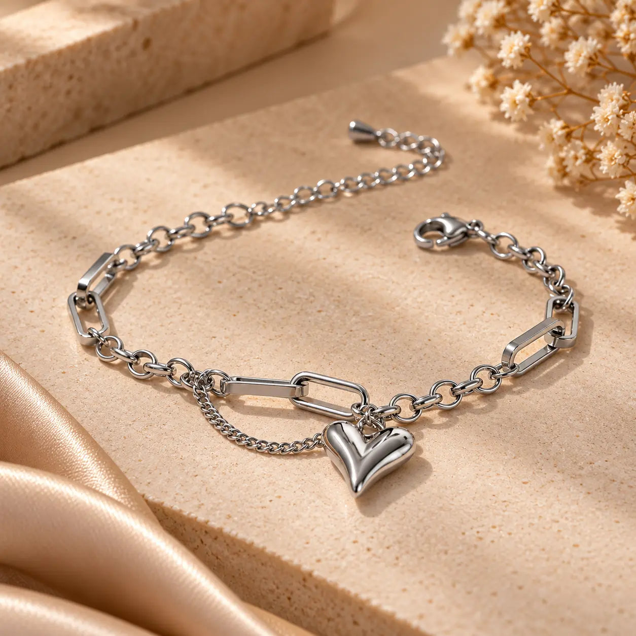 Silver tone heart charm link chain bracelet shown in a close product view