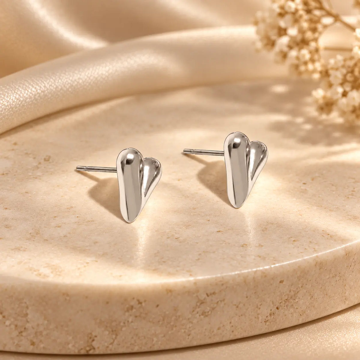 Silver heart stud earrings with a sleek polished finish