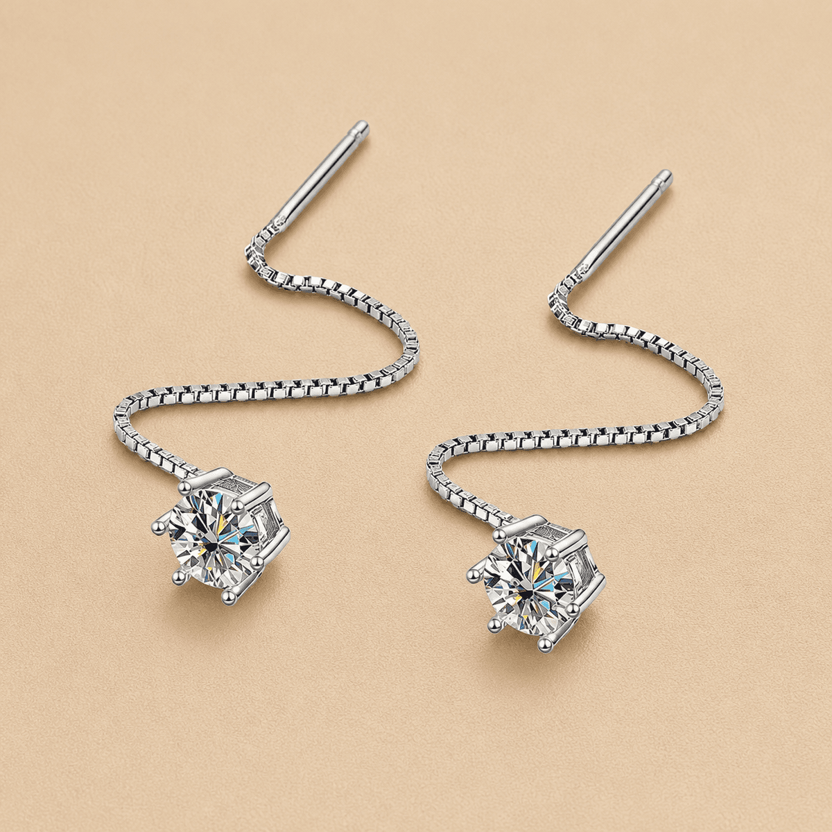 silver moissanite threader earrings close up on beige background