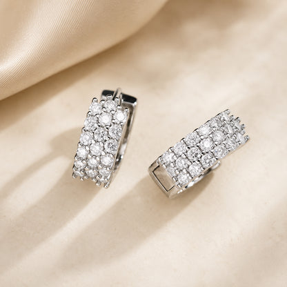 Silver moissanite hoop earrings displayed on soft silk fabric with a clean luxury jewelry look.
